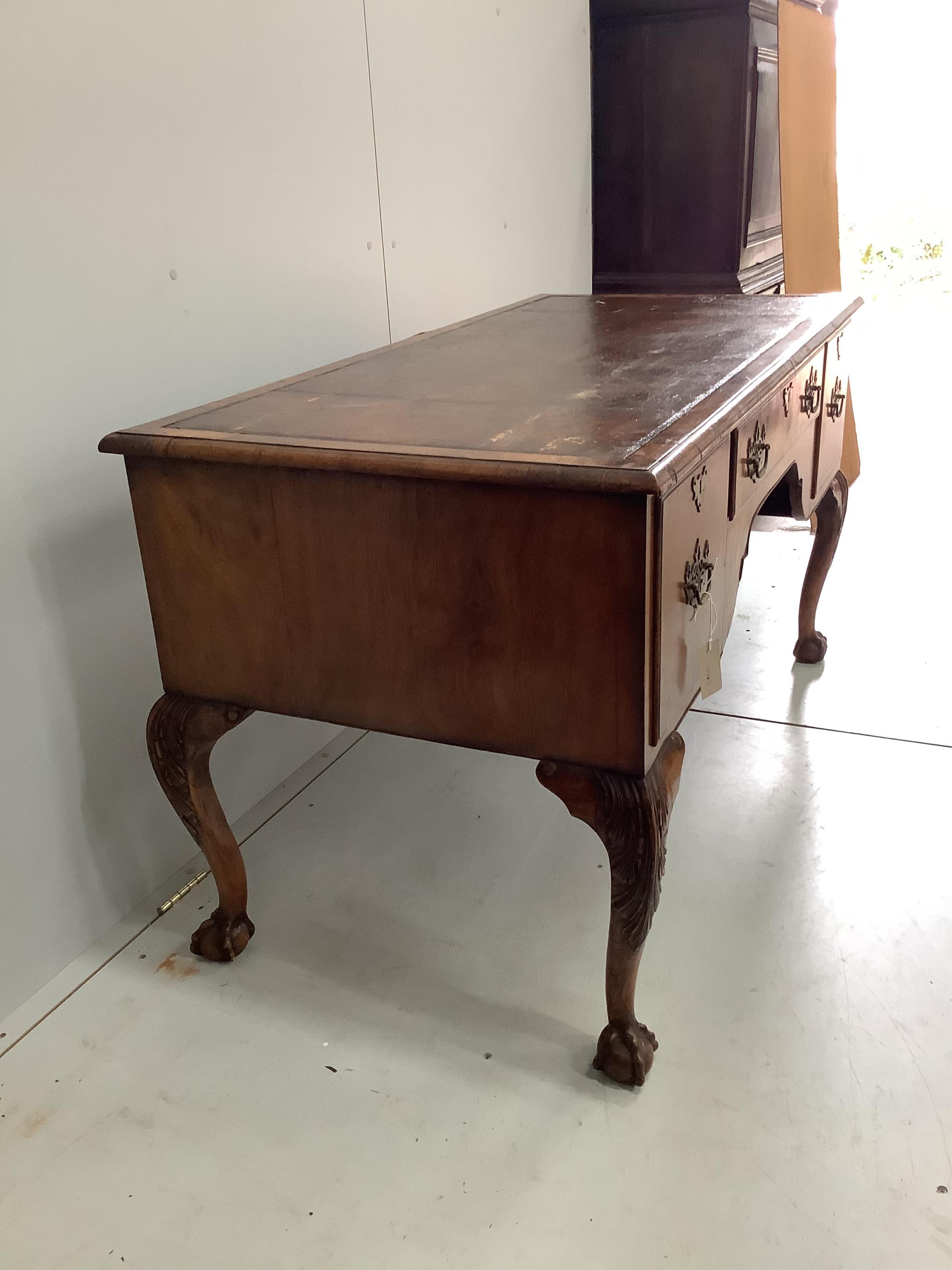 A 1930's walnut kneehole walnut writing table, width 148cm, depth 68cm, height 76cm. Condition - fair to good